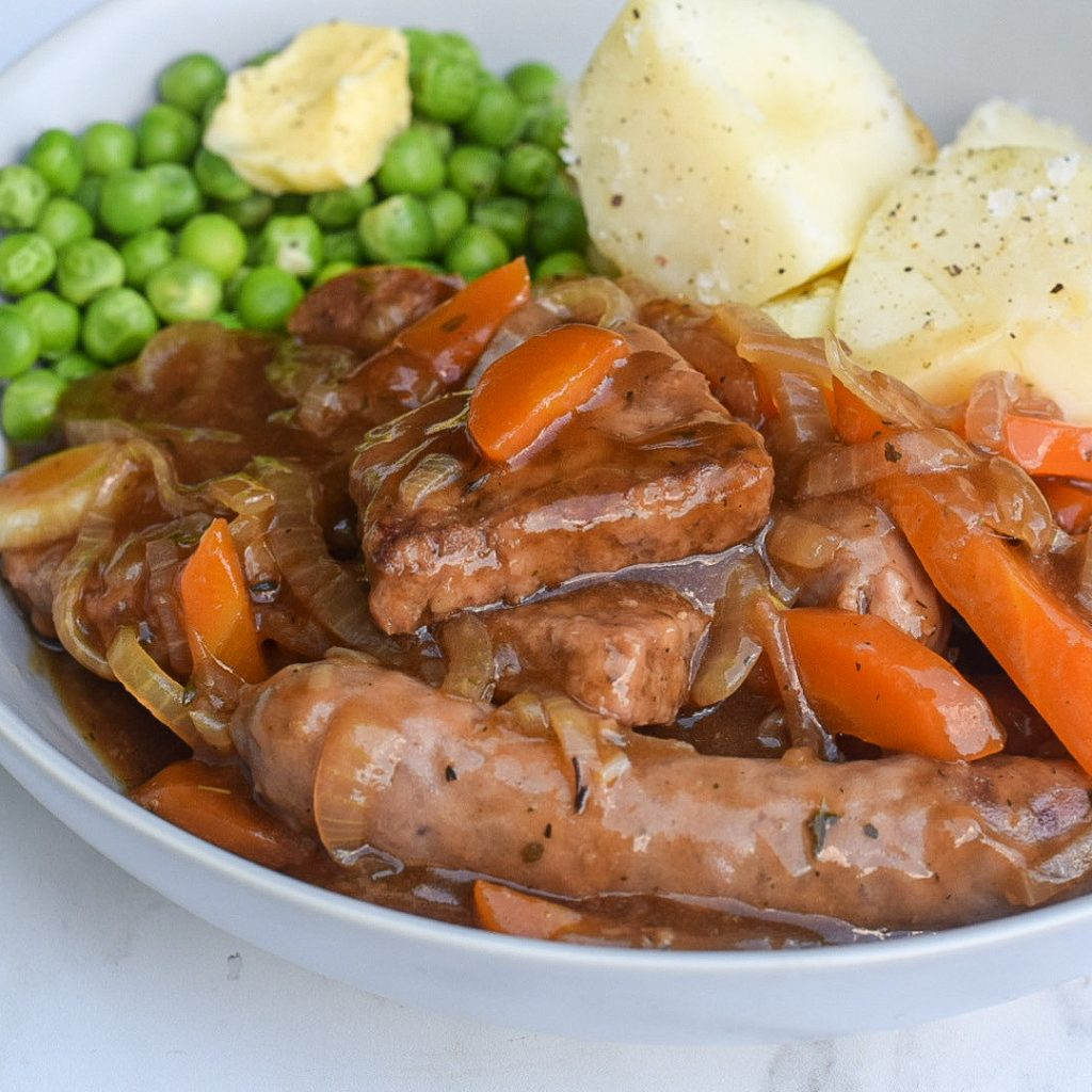 stewed sausages with boiled potatoes and peas in a bowl