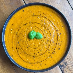 tomato and basil soup in a black bowl