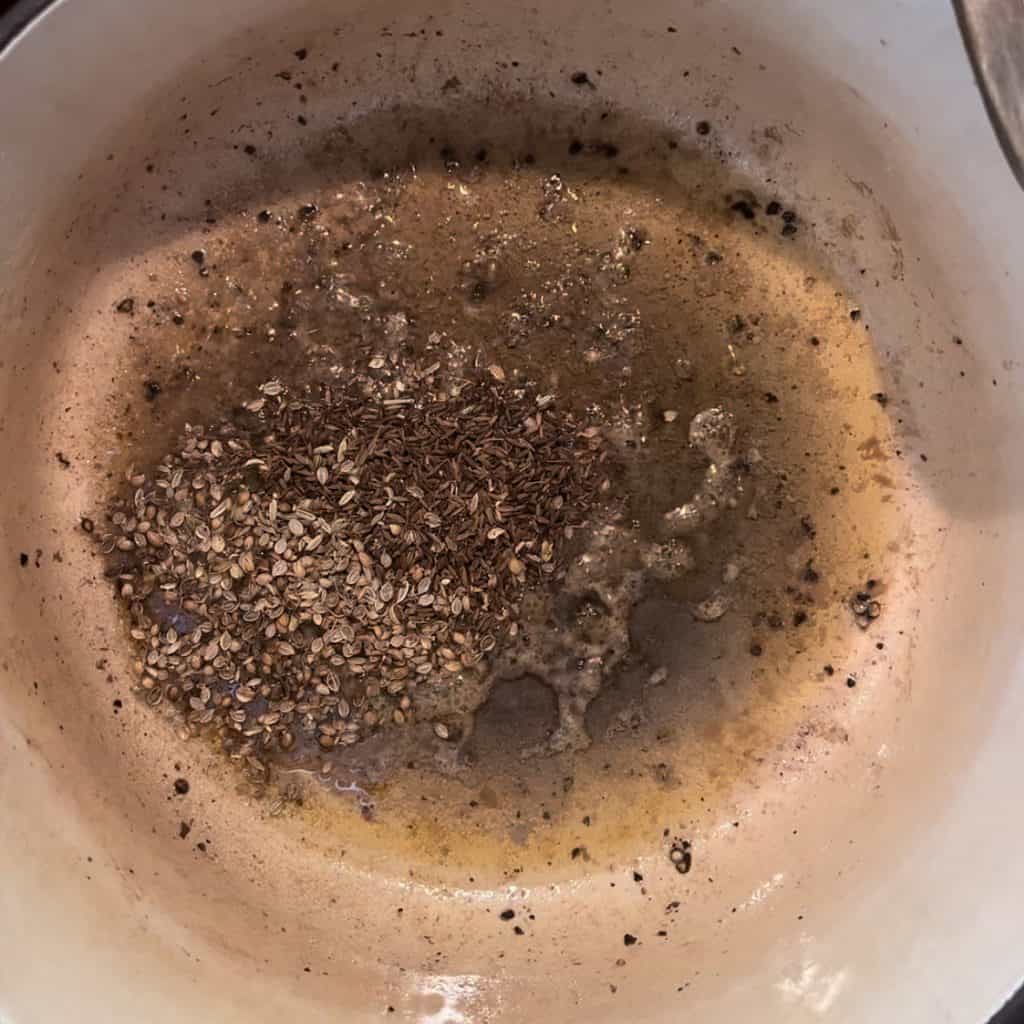 whole spices in a large pot in ghee