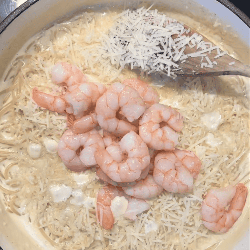 cooked prawns being added to Alfredo pasta