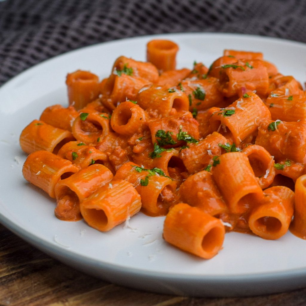 prosecco pasta with Italian sausage on a plate garnished with parsley